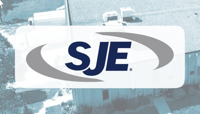 SJE company logo overlaid on a background of a manufacturing facility, representing 95% automated matching and audit readiness using OneStream.